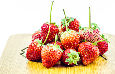 Heap of fresh ripe strawberries on wooden table on blurred wooden background,Close up