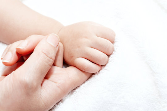 Mother holding hand of a baby