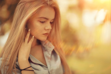 Naklejka premium portrait of a beautiful young blonde woman with sun rays and glare