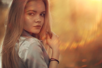 portrait of a beautiful young blonde woman with sun rays and glare