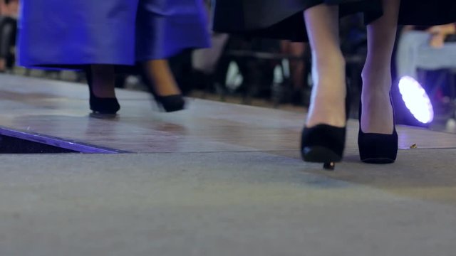 Slim legs in High-heeled shoes, Group of models walk on catwalk at fashion show, catwalk models, presentation collections footwear, girls walk on catwalk in high heels at fashion week, close-up shoes,