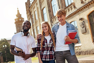 Group of positive friends enjoying a walk around campus