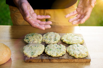 Man showing dirty hands after preparing meat and zucchini burgers, bbq summer garden food concept