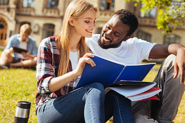 Charismatic positive guy helping his friend with the subject