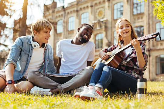 Lively sincere guys enjoying their friends song