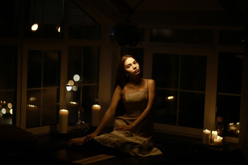 Fototapeta na wymiar Romantic evening with candles girl, candles, house