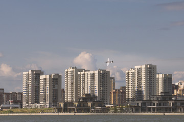 Fototapeta premium Sportive airplane flying over modern city