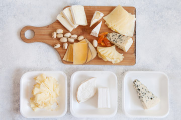 Cheese plate served with grapes, jam, cured melon, crackers and nuts