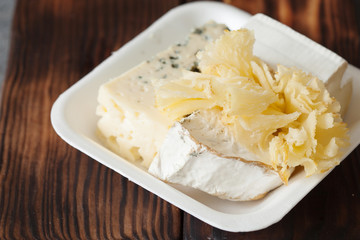 Cheese plate served with grapes, jam, cured melon, crackers and nuts