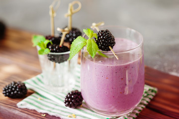 Delicious blackberry smoothie with mint and fresh berries in glass