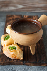 Russian patties rasstegai with fish and fish bouillon