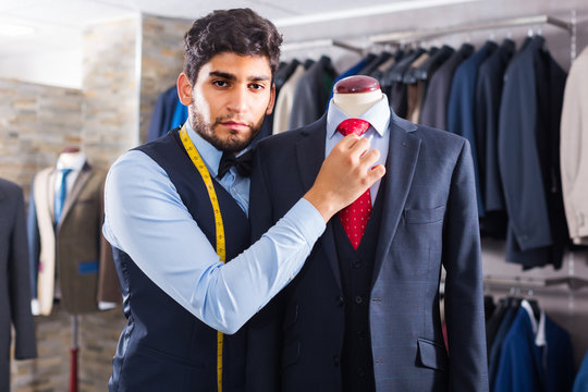 Adult male  is creating business image with red tie