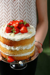 Summer cake with berry in woman's hands