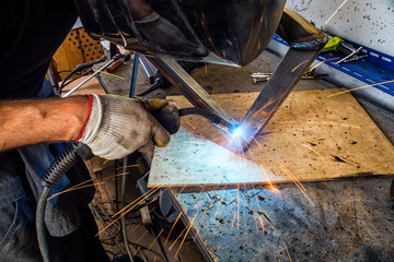 man welds with a welding machine