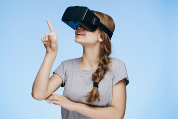 Young beautiful woman on a blue background with virtual reality glasses