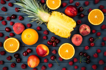 Fruits and berries. Assortment of exotic fruits. Pineapple, raspberries, peach, kiwi, citrus and cherry. Flat lay, top view