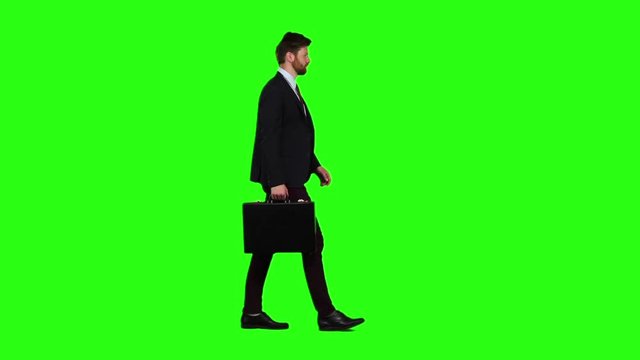 Man holds a briefcase in his hand, he rushes over it. Green screen. Slow motion