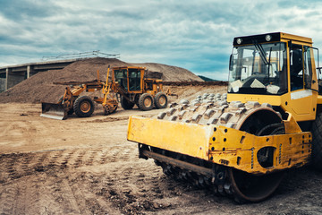 Vibratory roller, Soil compactor, Bulldozer and other industrial machinery on highway construction site