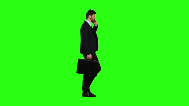 Man is a diplomat, a telephone rings to him and he talks. Green screen. Slow motion