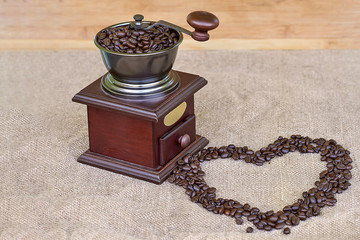 Coffee grinder full of roasted coffee beans and coffee beans heart shape