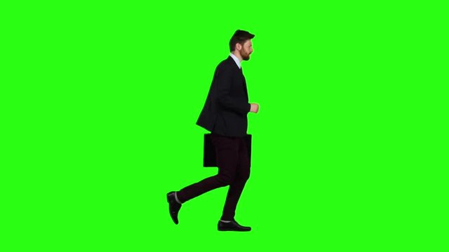 Man is running a briefcase in his hand, he rushes over it. Green screen. Slow motion