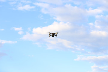 Quadcopter with camera flying on a clear sunny sky sunset background with nice lens flare.