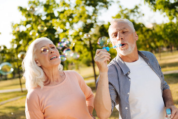 Fototapeta premium Relaxed mature man blowing bubbles