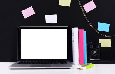 Stylish workspace with laptop, camera, sticky notes.