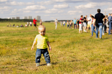 Cute one year boy on the lawn on the summer fest