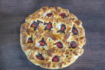 strawberries pie on dark wooden background top view