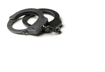 Metal police handcuffs on a white background with potential copy space