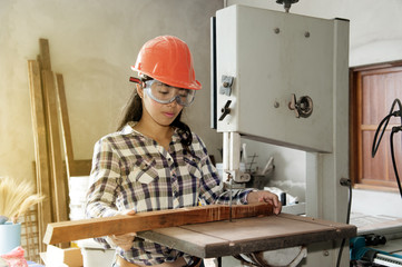 Asian pretty female carpenter Using Electric Sander for wood