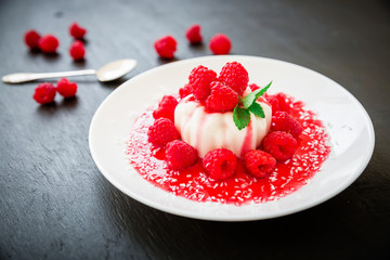 Delicious Panna cotta in a plate and raspberries