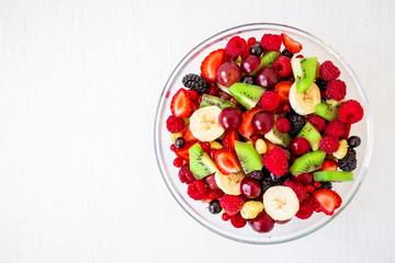 Tasty fruit salad on white rustic background. Flat lay, Top view. Natural food
