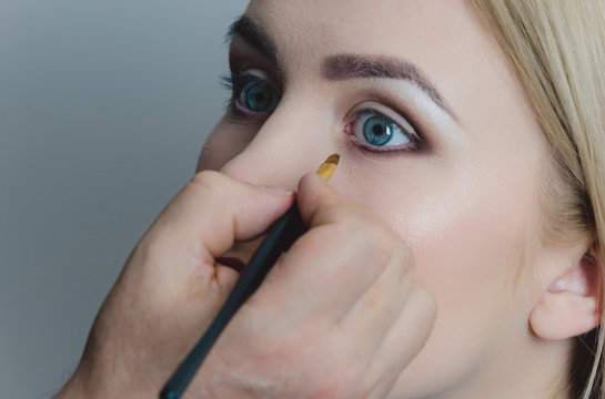 Woman with blue eyes getting makeup