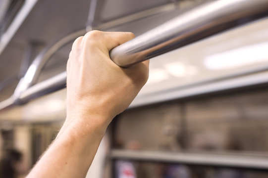 A Man's Hand Holds On To The Rail In The Subway