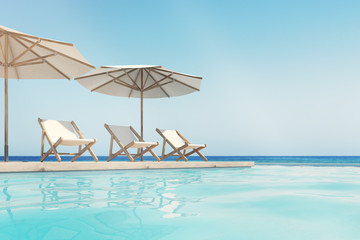 Swimming pool, deck chairs, umbrellas, horizon