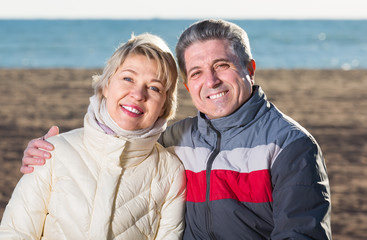 smiling husband and wife spend time together happily at sea beach