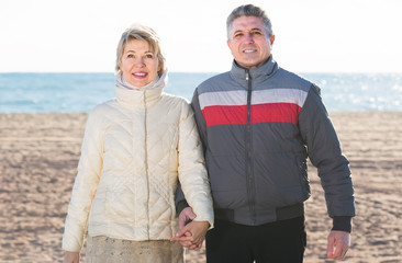 middle-aged husband and wife spend time together happily at sea beach