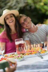 Group of friends lunching in the garden, focus on dishes