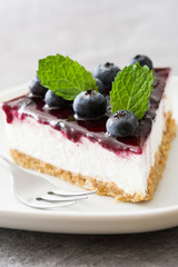 Piece of blueberry cheesecake on gray stone
