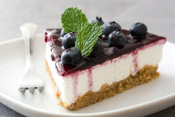 Piece of blueberry cheesecake on gray stone
