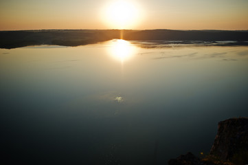 Breathtaking view of a lake surrounded by mountains andd hills.