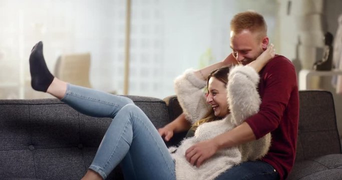 Young couple having fun and cuddling on the couch