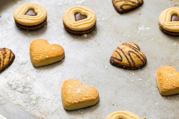 Gebäck Kekse mit Schokolade in Form als Herz liegen dekorativ nach dem Backen auf Backblech