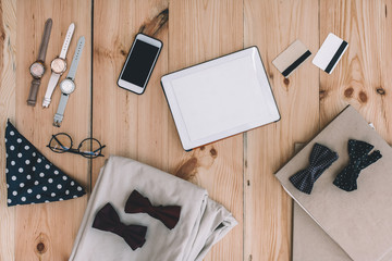 top view of smartphone, digital tablet, credit cards and stylish accessories on wooden table top