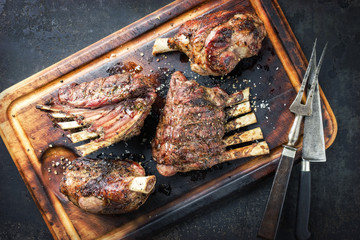 Barbecue Leg of Lamb and Veal Loin as top view on burnt cutting board
