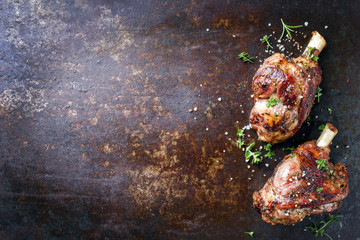 Two Barbecue Leg of Lamb as top view on old rusty metal sheet © HLPhoto