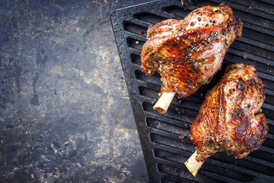 Two Barbecue Leg of Lamb as top view on cast iron grillage