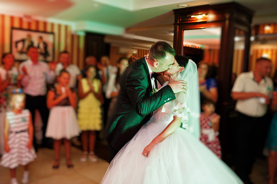 Beautiful couple dancing in the restaurant with different lights and smoke on their wedding day.